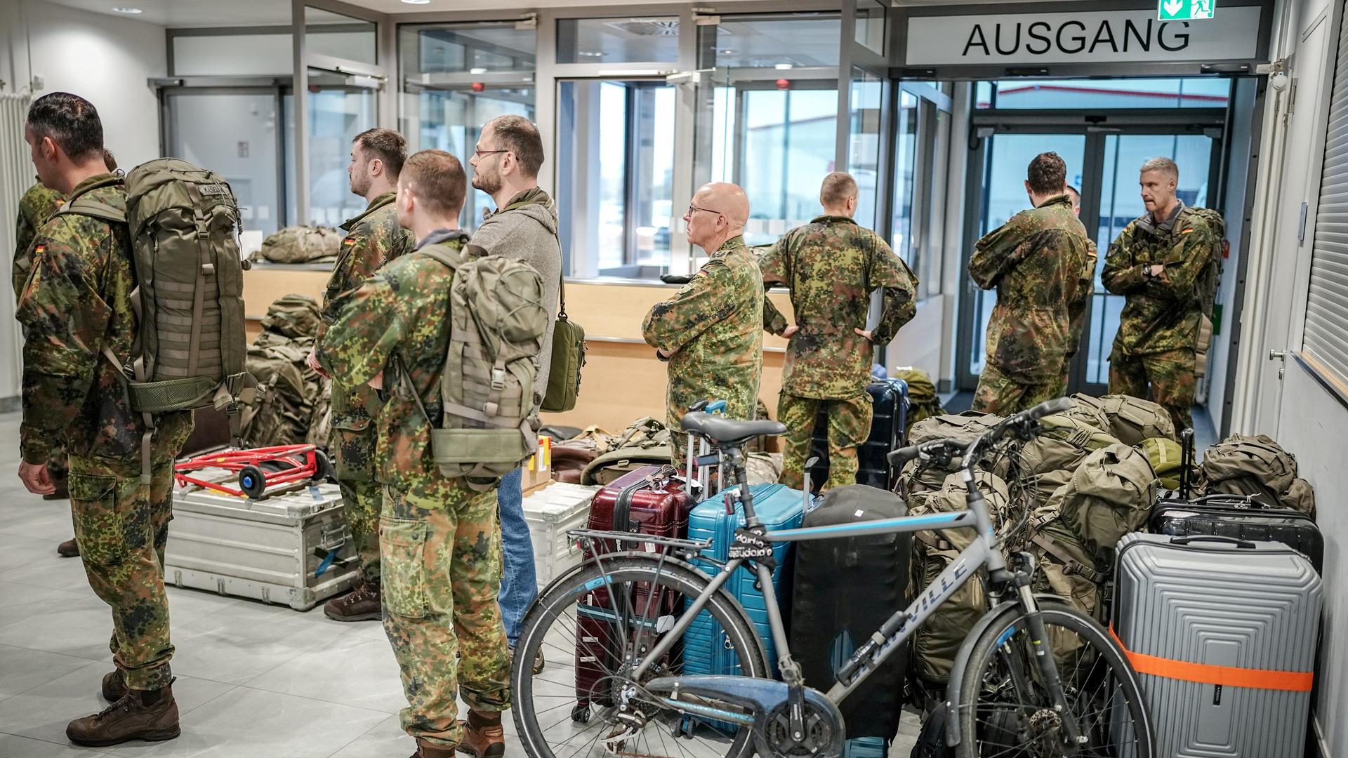 Soldaten der Bundeswehr stehen in einer Wartehalle auf dem militärischen Teil des Flughafens Berlin-Brandenburg.