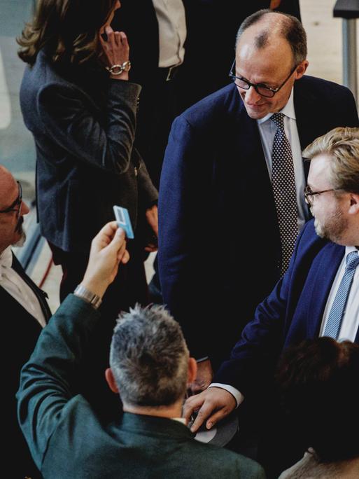 Blick in die Abstimmung über das Rentenpaket im Deutschen Bundestag in Berlin, zu sehen sind mehrere Abgeordnete sowie Bundeskanzler Merz. Einer der Abgeordneten hält eine Stimmkarte in die Höhe. Blick in die Abstimmung über das Rentenpaket im Deutschen Bundestag in Berlin, zu sehen sind mehrere Abgeordnete sowie Bundeskanzler Merz. Einer der Abgeordneten hält eine Stimmkarte in die Höhe.