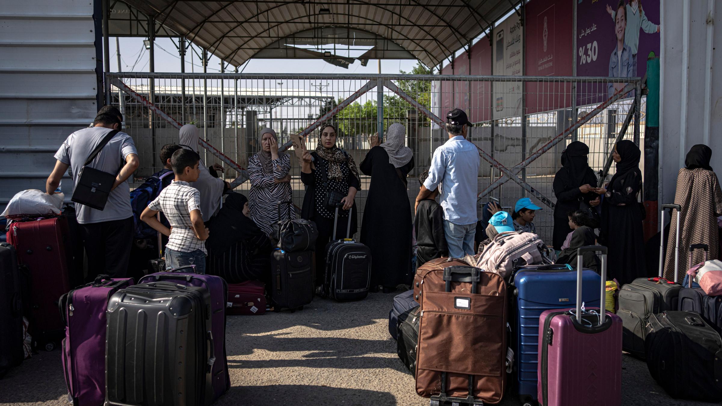 Zu sehen sind Menschen, die am Grenzübergang Rafah auf ihre Ausreise nach Ägypten warten.