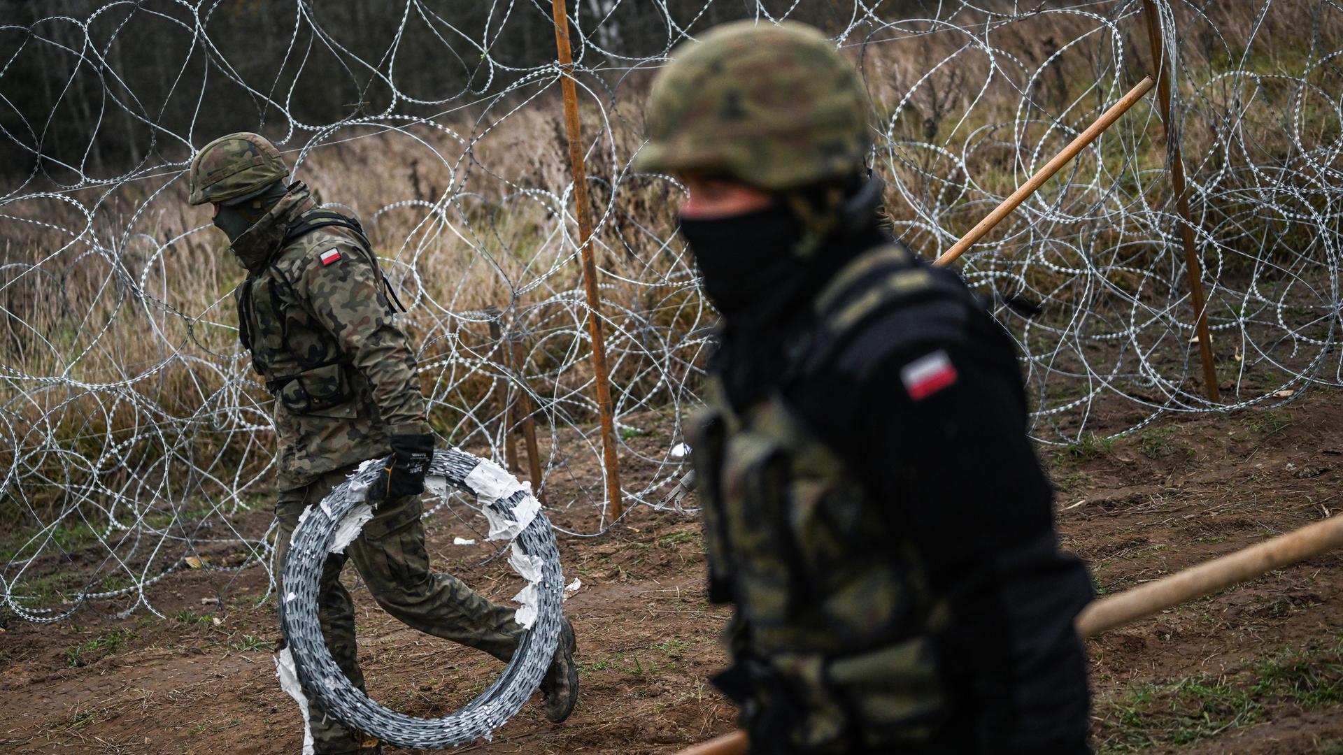 Polnischen Soldaten tragen Stacheldraht und errichten eine Barriere an der polnisch-russischen Exklave Kaliningrad.