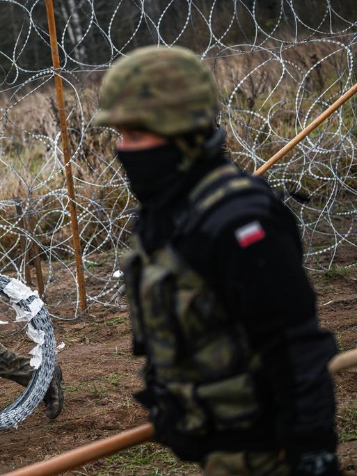 Polnischen Soldaten tragen Stacheldraht und errichten eine Barriere an der polnisch-russischen Exklave Kaliningrad.