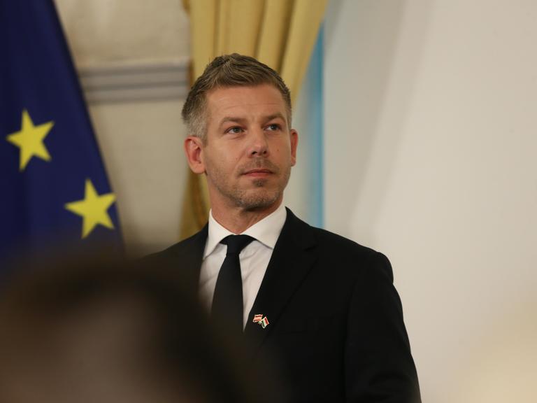 Ungarns Regierungschef Peter Magyar steht in einer Pressekonferenz vor einer EU-Flagge.