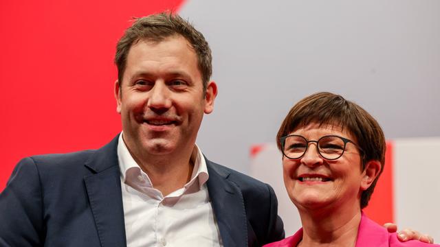 Lars Klingbeil und Saskia Esken stehen nahe nebeneinander und lächeln.