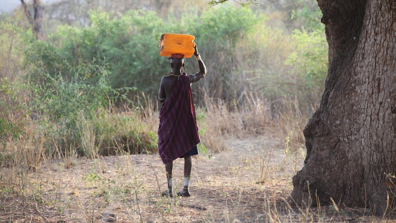 Eine Mursi-Frau transportiert im äthiopischen Omo-Tal einen Wasserkanister von einem Fluss zu ihrem Dorf.