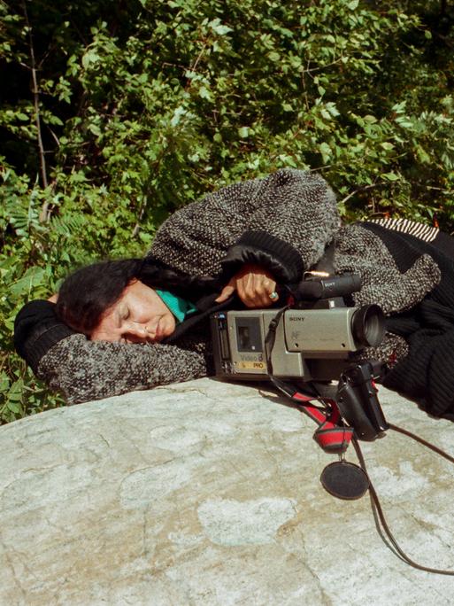 Eine Fotografie zeigt die kanadische Filmemacherin Alanis Obomsawin schlafend auf einem Felsen. | Sleeping During the Oka Crisis, 1990