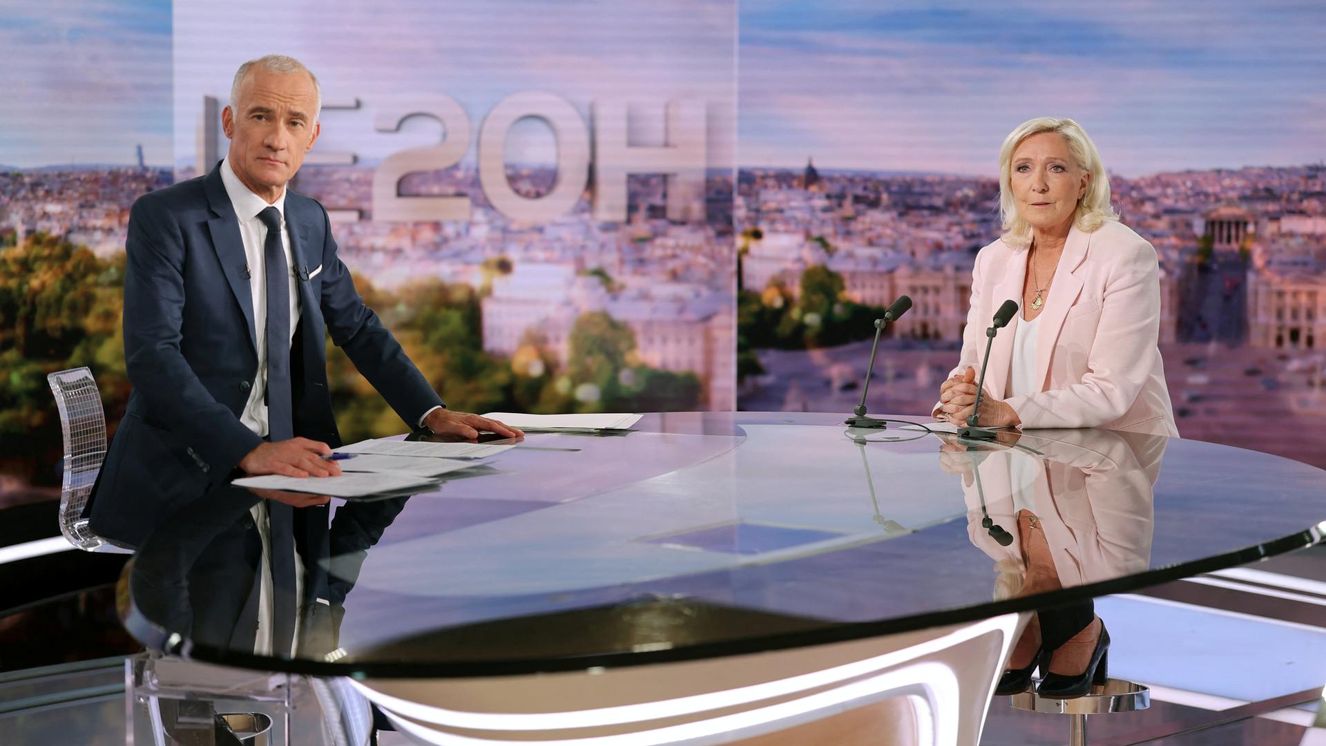 Die französische Politikerin des Rassemblement National, Marine Le Pen, posiert mit einem Journalisten vor einem Interview in einem Fernsehstudio. Die französische Politikerin des Rassemblement National, Marine Le Pen, posiert mit einem Journalisten vor einem Interview in einem Fernsehstudio.