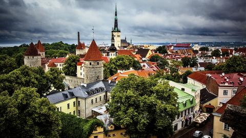 Panoramablick über Tallinn: Zu sehen sind vor gewitterartig bewölktem Himmel Kirchenspitzen und mittelalterlich anmutende Gebäude