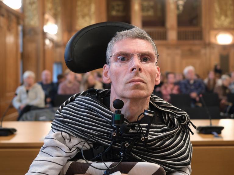 Harald Mayer, durch Multiple Sklerose komplett bewegungsunfähig, sitzt in einem Saal des Bundesverwaltungsgerichtes (BVerwG). Mayer wünscht sich Sterbehilfe.