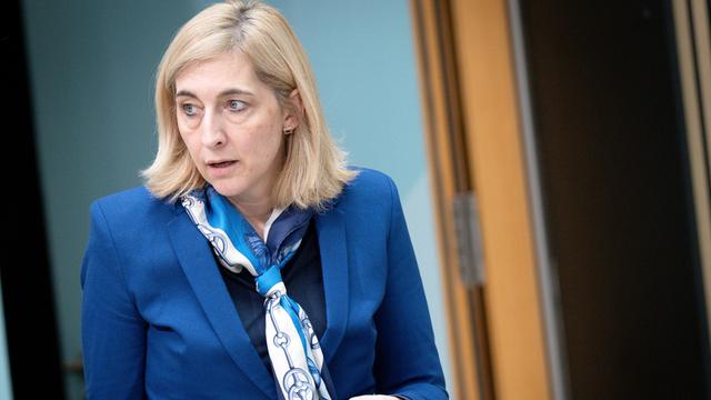 Bundesgesundheitsministerin Nina Warken hält ein Handy in ihrer linken Hand.