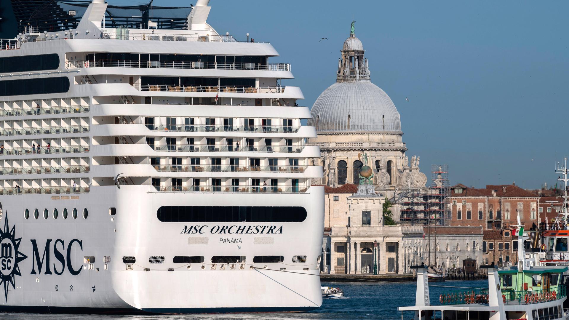 Ein großes Kreuzfahrtschiff fährt an Venedig vorbei. Die Stadt wirkt klein und fragil im Vergleich zu dem Luxusdampfer.