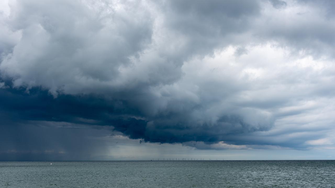 Über der Ostsee bei Prerow ziehen dichte, dunkle Regenwolken auf. Eine drohende Unwetterfront verdunkelt den Himmel.