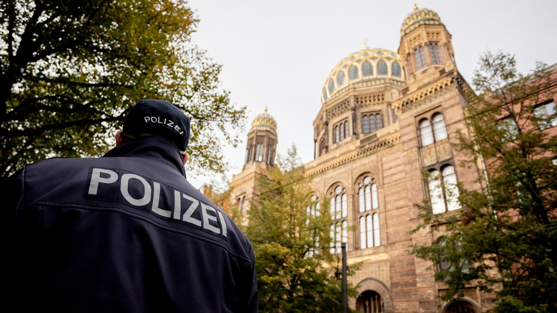 Ein Polizeibeamter läuft vor der Neuen Synagoge Berlin.