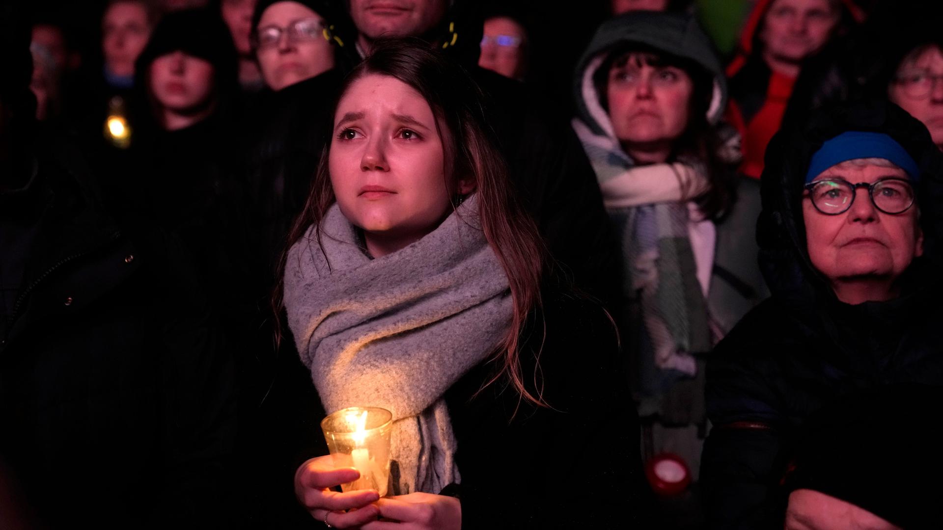 Menschen in Magdeburg verfolgen einen Gedenkgottesdienst für die Opfer des Anschlags auf den Weihnachtsmarkt.