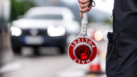 Ein Polizist steht im Mai an der Grenzkontrollstelle der Bundespolizei an der A 93 bei Kiefersfelden (Bayern) an der deutschen Grenze am Straßenrand der Autobahn und hält seine Kelle in der Hand. 