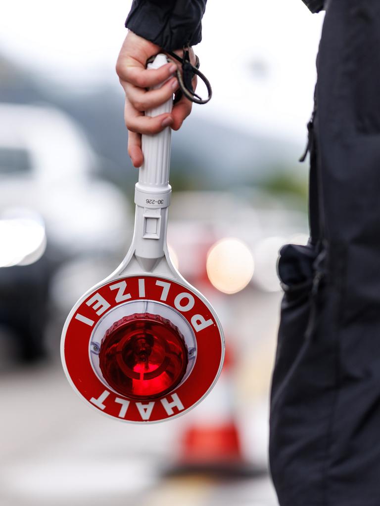 Ein Polizist steht im Mai an der Grenzkontrollstelle der Bundespolizei an der A 93 bei Kiefersfelden (Bayern) an der deutschen Grenze am Straßenrand der Autobahn und hält seine Kelle in der Hand. 