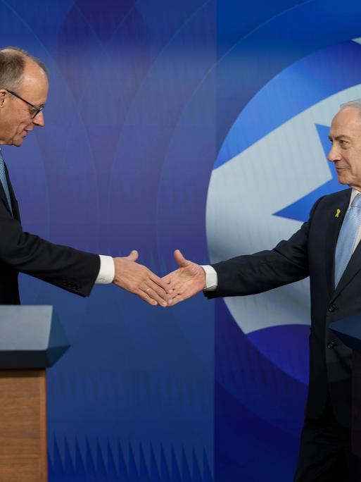 Bundeskanzler Friedrich Merz  schüttelt die Hand des israelischen Ministerpräsidenten Benjamin Netanjahu während einer Pressekonferenz.