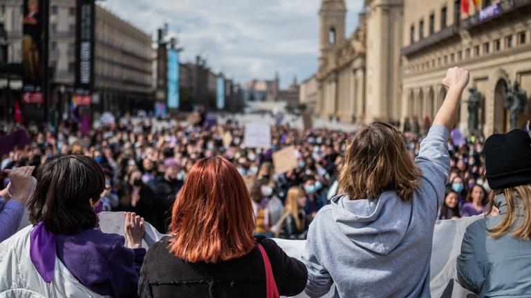 Hunderte Frauen sind auf dem Plaza del Pilar im spanischen Saragossa zum internationalen Frauentag am 8. Mai versammelt, tragen Plakate und recken Fäuste in den Himmel Hunderte Frauen sind auf dem Plaza del Pilar im spanischen Saragossa zum internationalen Frauentag am 8. Mai versammelt, tragen Plakate und recken Fäuste in den Himmel