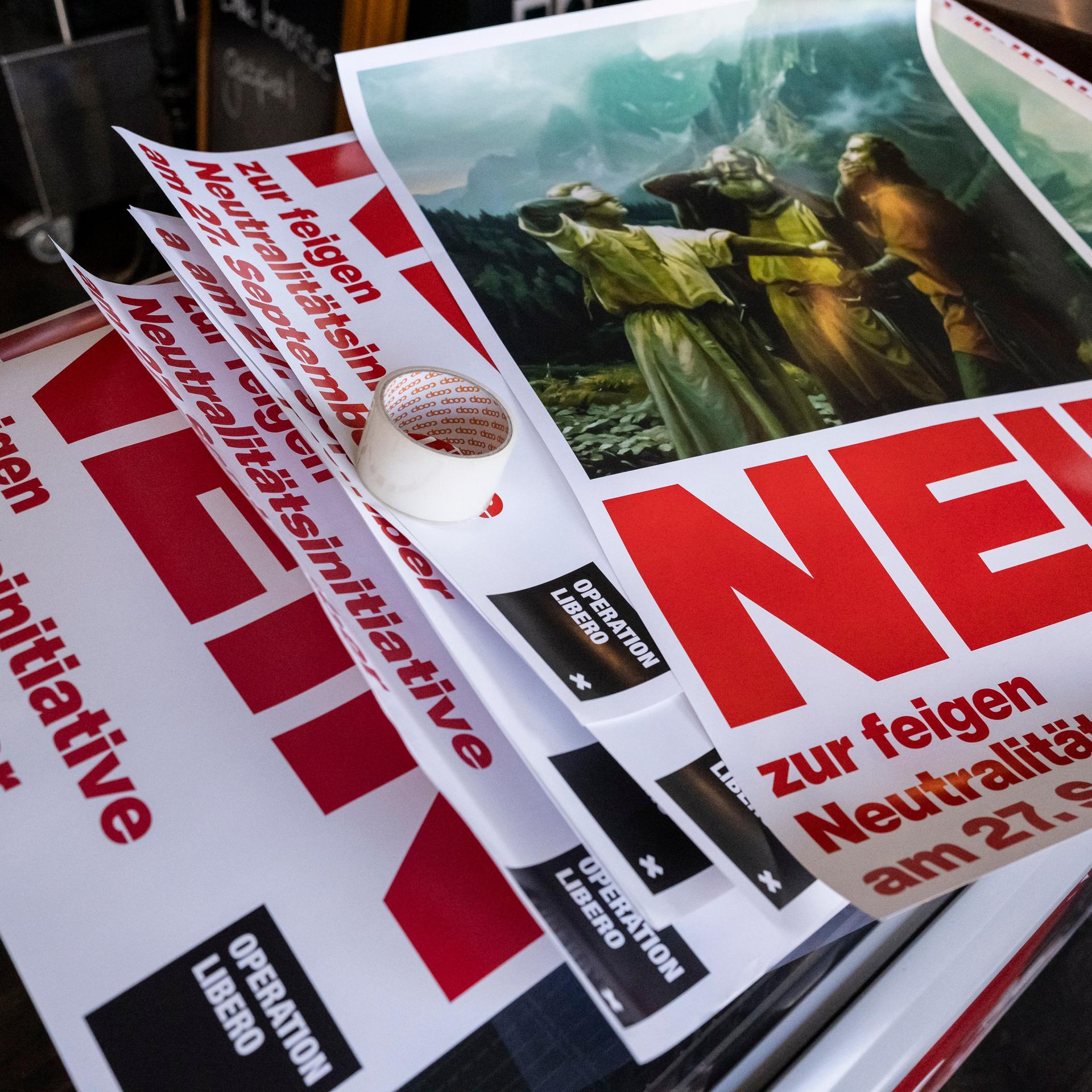 Abstimmungsplakate gegen die Neutralitätsinitiative liegen auf einem Stapel
