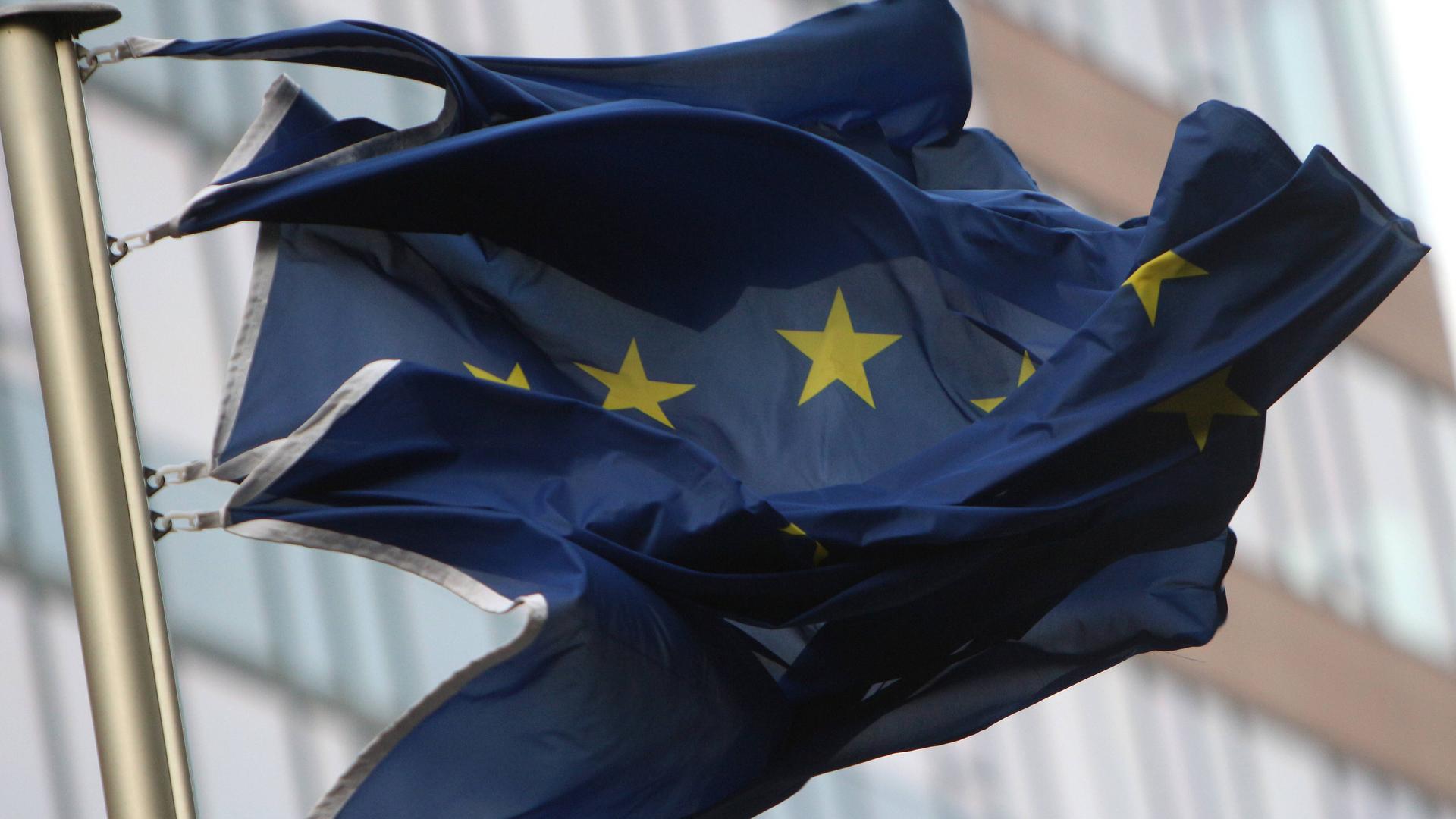 Eine EU-Flagge hängt an einem Mast und wird vom Wind fast zerrissen.