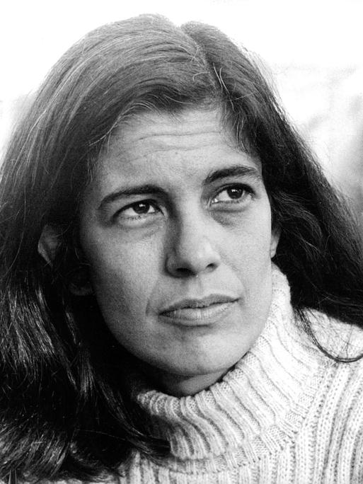 Schwarzweißporträt von Susan Sontag, die mit ernster Miene ins Off des Bildes blickt.