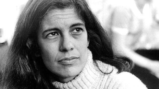 Schwarzweißporträt von Susan Sontag, die mit ernster Miene ins Off des Bildes blickt.