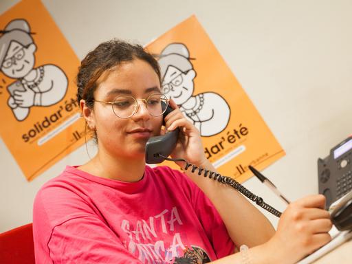 Eine junge Person sitzt in einem Büro und telefoniert. 