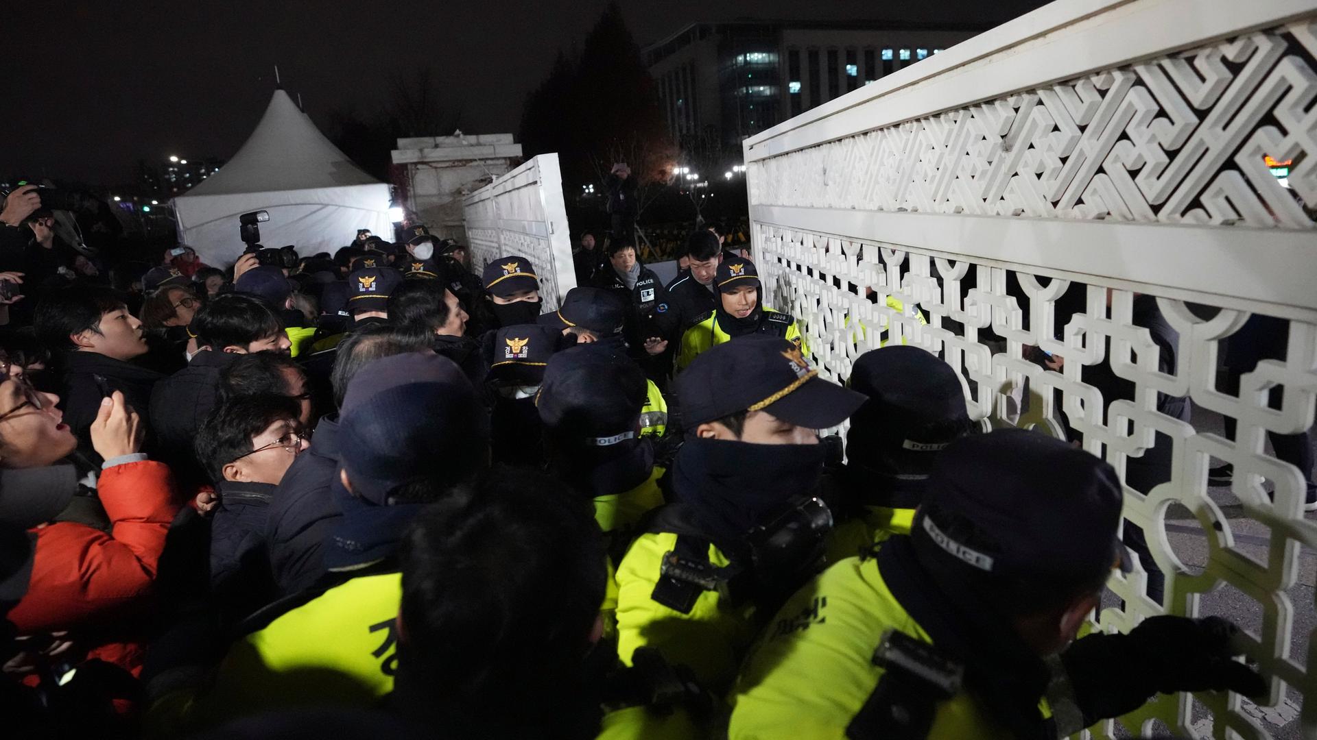 Südkorea, Seoul: Menschen versuchen in die Nationalversammlung zu gelangen, während Polizisten Wache stehen. 