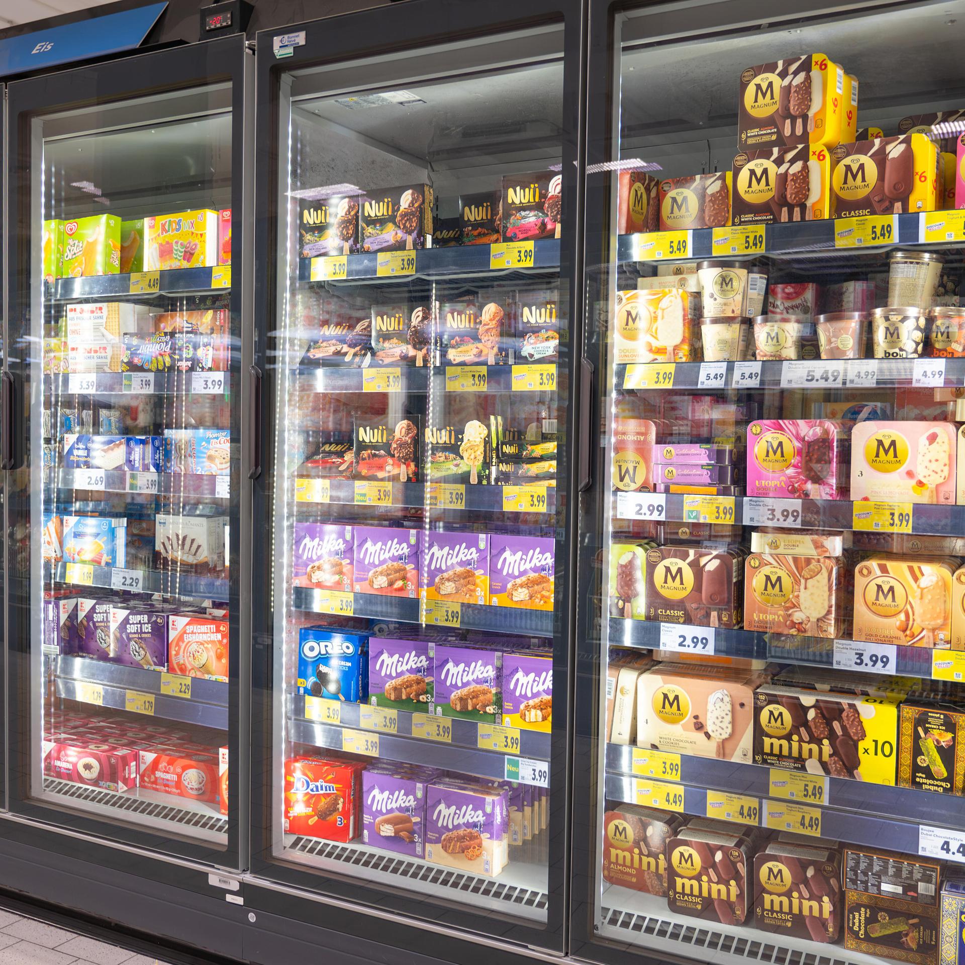 Eissortiment mit Schokoladen-, Frucht-, Vanille-, Nuss- und Kaffeegeschmack in den Regalen eines Supermarkts in Trier