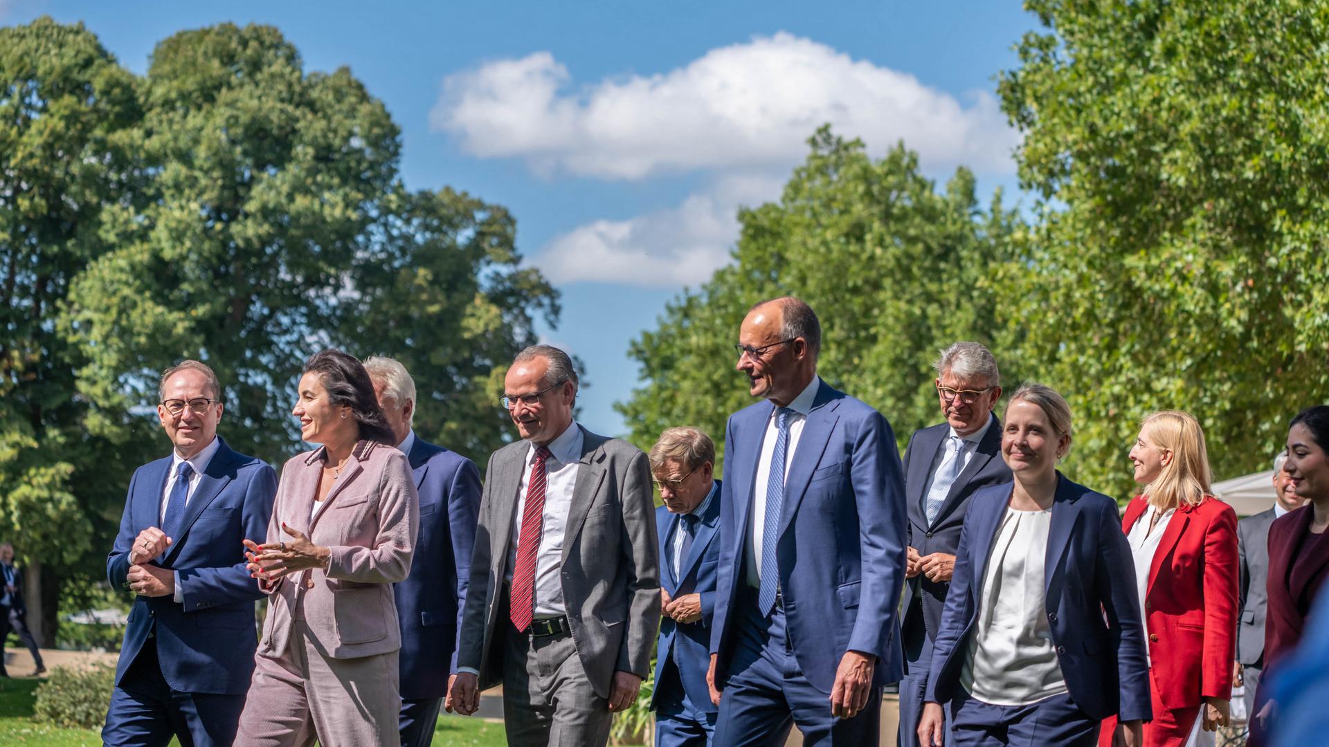 Dobrindt, Bär, Krichbaum, Wadephul, Merz, Weimer, Hubertz, Waren-Alabali Radovan kommen zum Gruppenfoto zusammen.