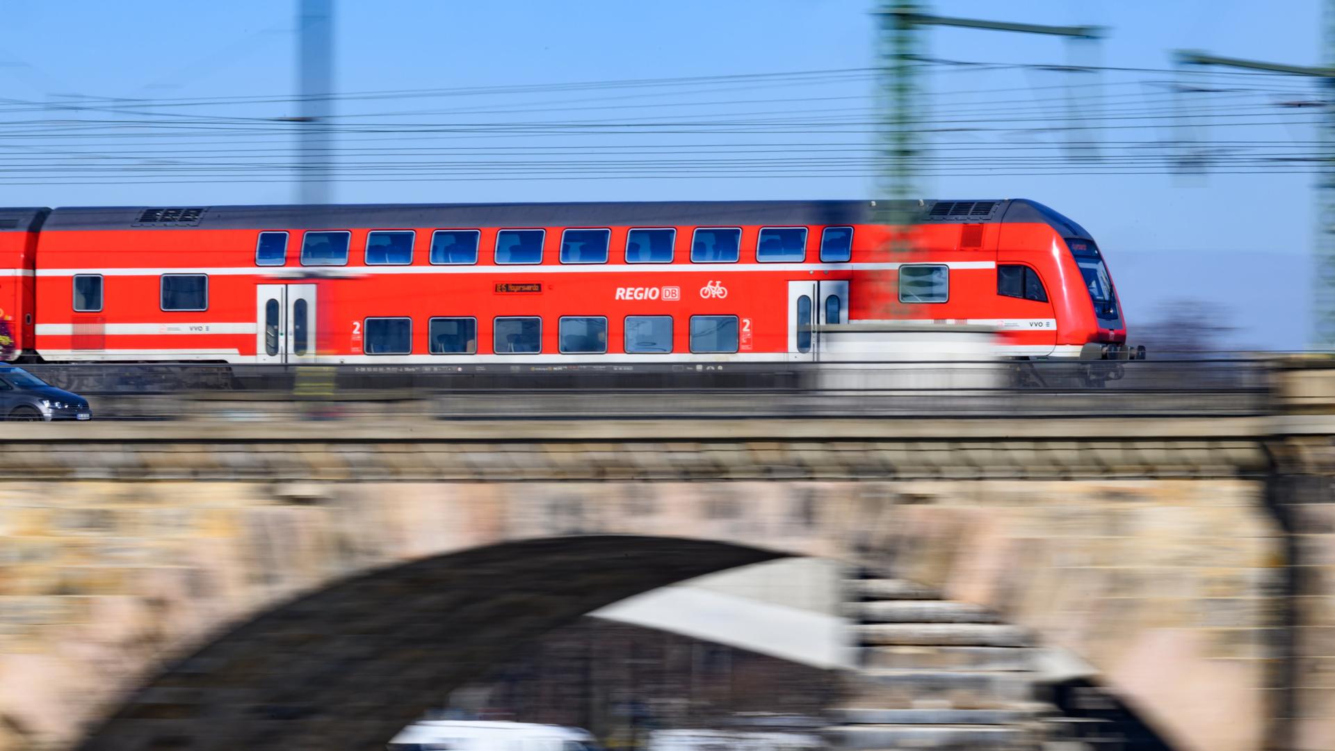 Ein Regionalexpress der Deutschen Bahn fährt über eine Brücke. 