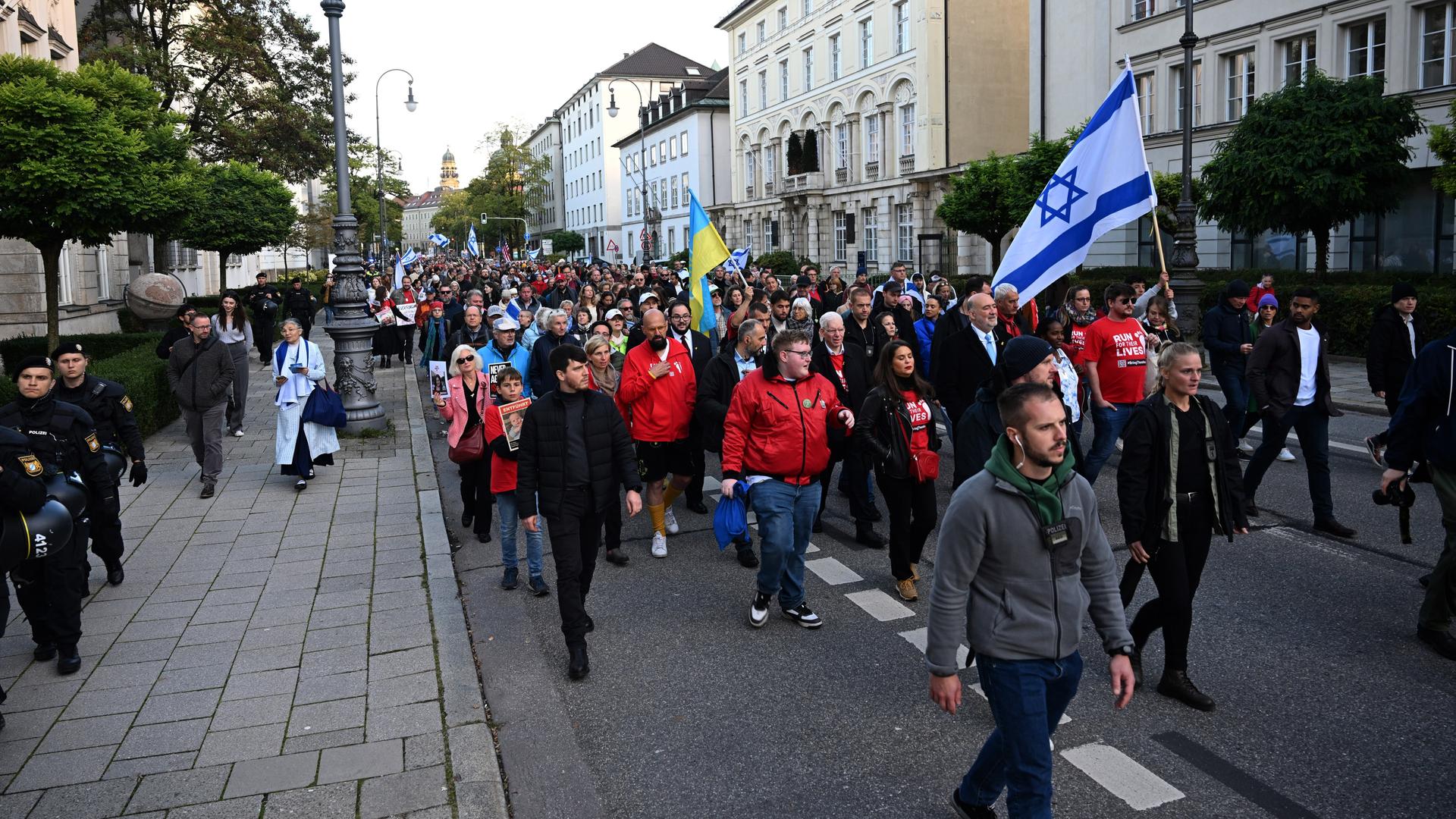 Menschen mit Israel-Flagge laufen durch München