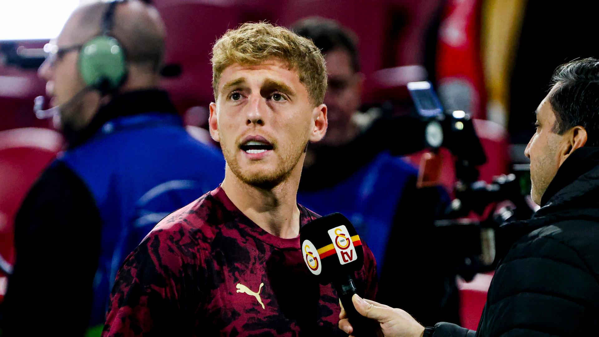 Metehan Baltaci schaut nach rechts, vor ihm steht ein Journalist mit einem Mikrofon.