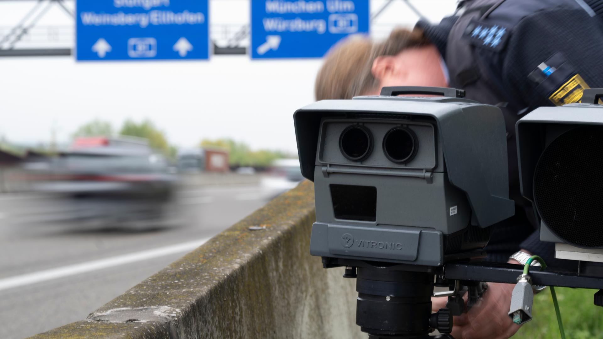 Eine mobile Geschwindigkeitsmessanlage der Autobahnpolizei Weinsberg wird am Rand der A6 von einem Polizeibeamten eingerichtet.