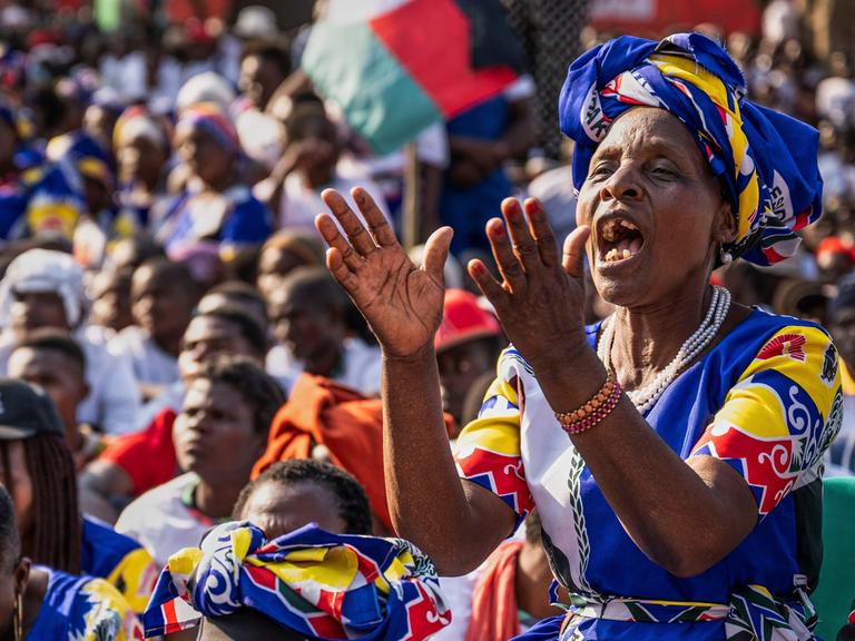 Eine Frau in buntem Kleid klatscht begeistert inmitten von anderen Menschen: Unterstützer der Malawi Congress Party (MCP) bei einer Wahlkampfveranstaltung.