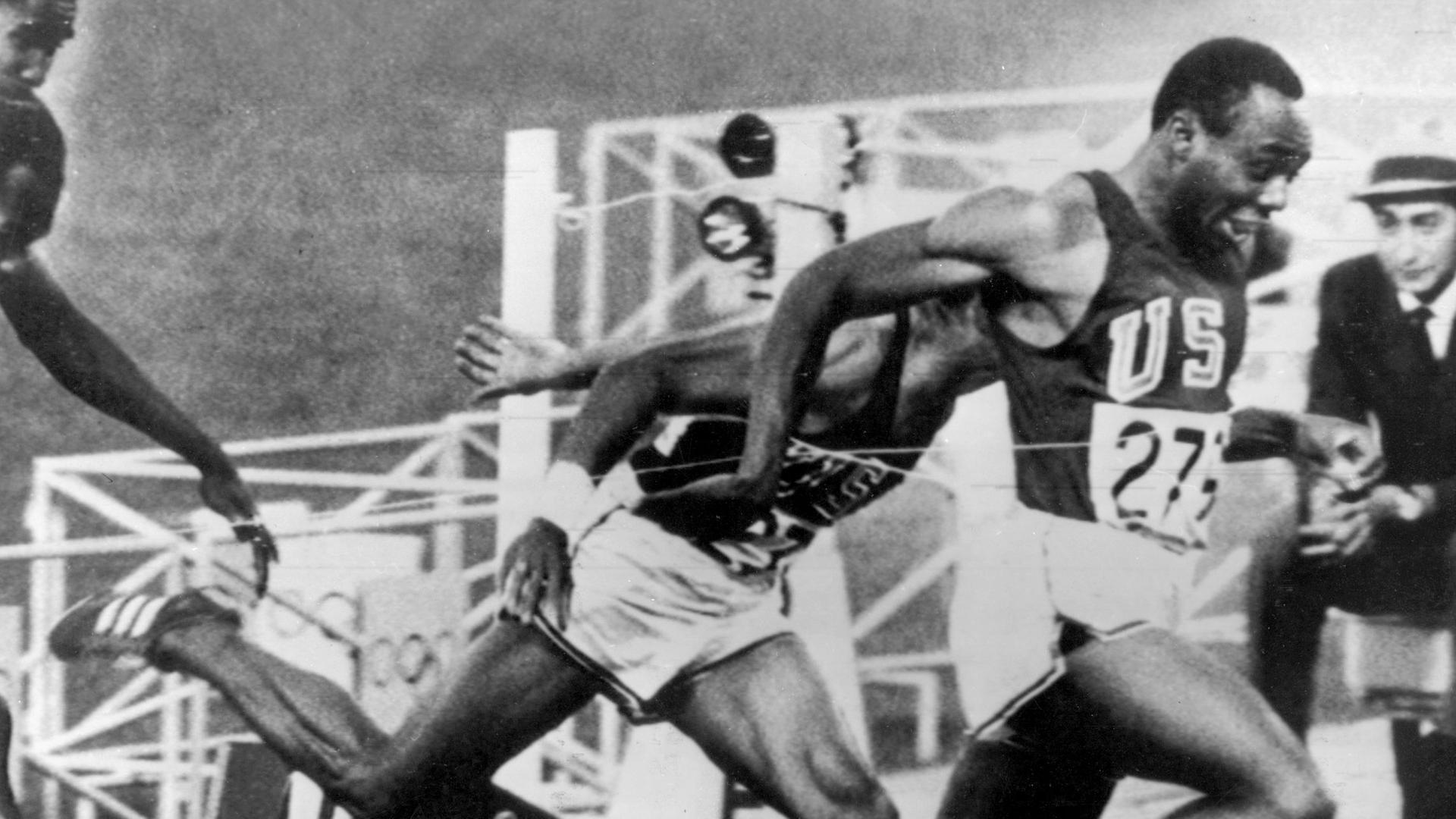 Im 100-m-Finale der Männer bei den Olympischen Sommerspiele im Olympiastadion in Mexiko-Stadt wirft sich USA-Sprinter Jim Hines (r) als erster in das Zielband.