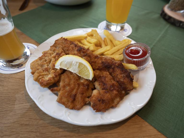 Wiener Schnitzel mit Pommes Frites in einer Wirtschaft serviert, Bayern, Deutschland, Europa