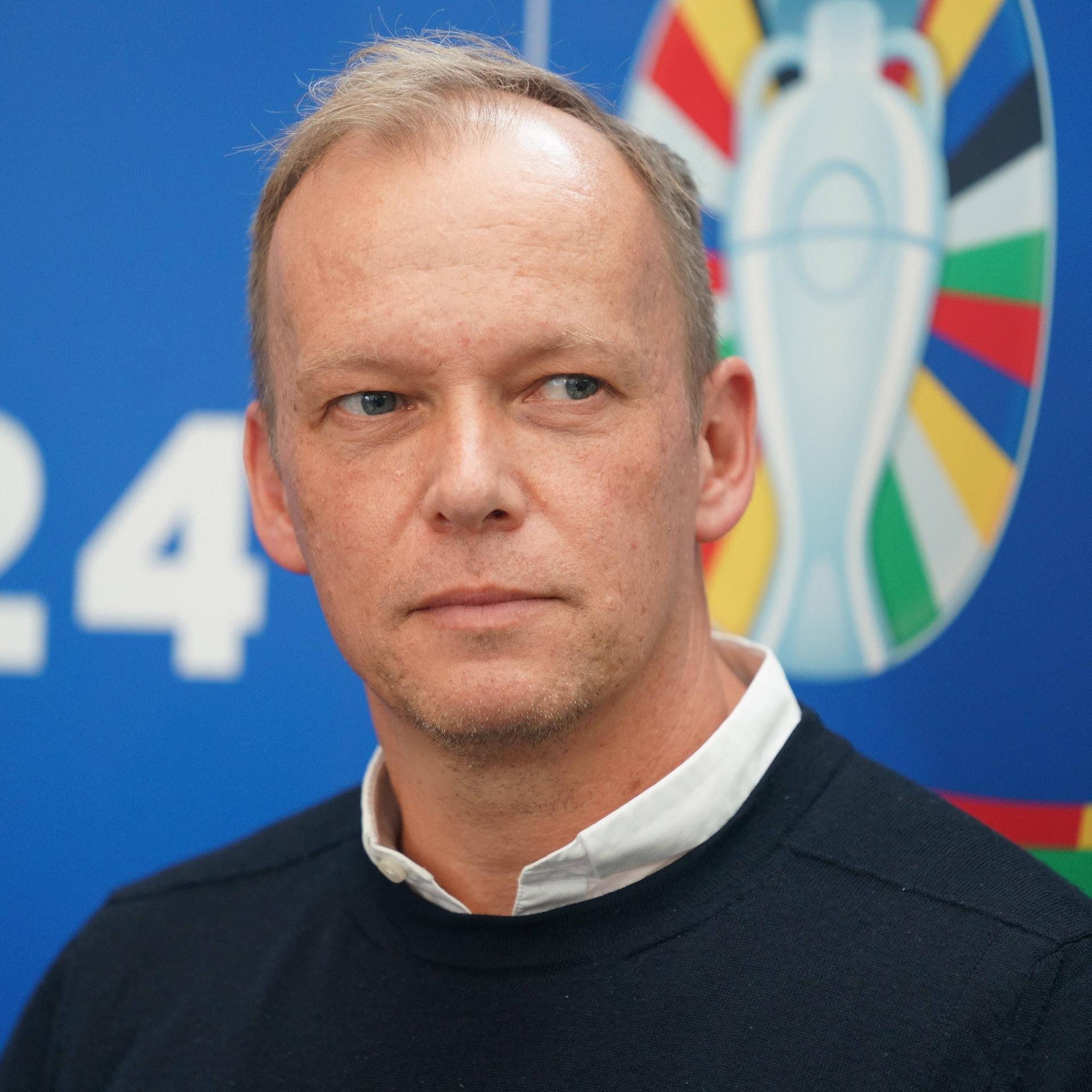 Zu sehen ist Markus Stenger, Geschäftsführer der EURO GmbH, vor dem Logo der EURO 2024 in Deutschland. 