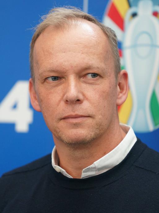 Zu sehen ist Markus Stenger, Geschäftsführer der EURO GmbH, vor dem Logo der EURO 2024 in Deutschland. 