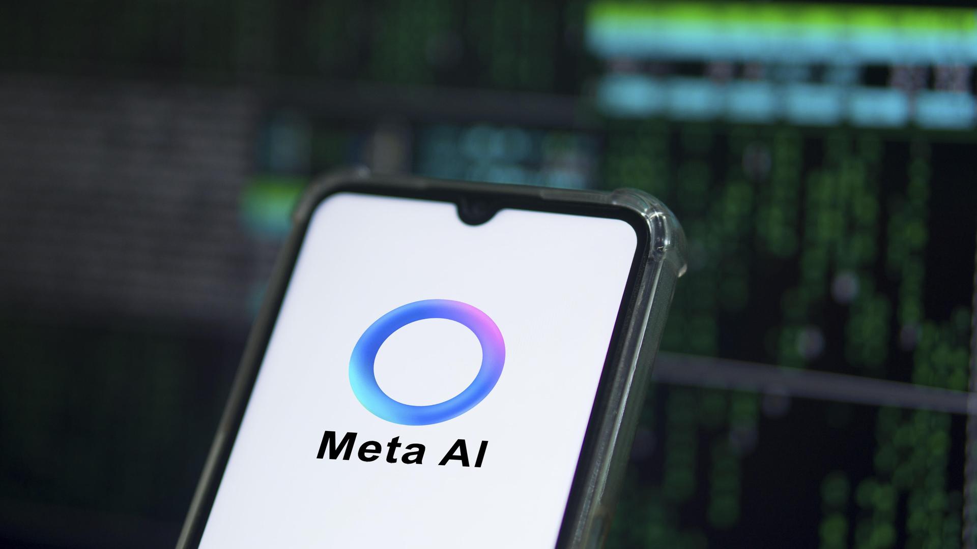 Auf einem Smartphone ist das Logo von Meta AI zu sehen: Ein überwiegend blauer Ring, der an manchen Stellen in Lila- und Grüntöne übergeht. Auf einem Smartphone ist das Logo von Meta AI zu sehen: Ein überwiegend blauer Ring, der an manchen Stellen in Lila- und Grüntöne übergeht.