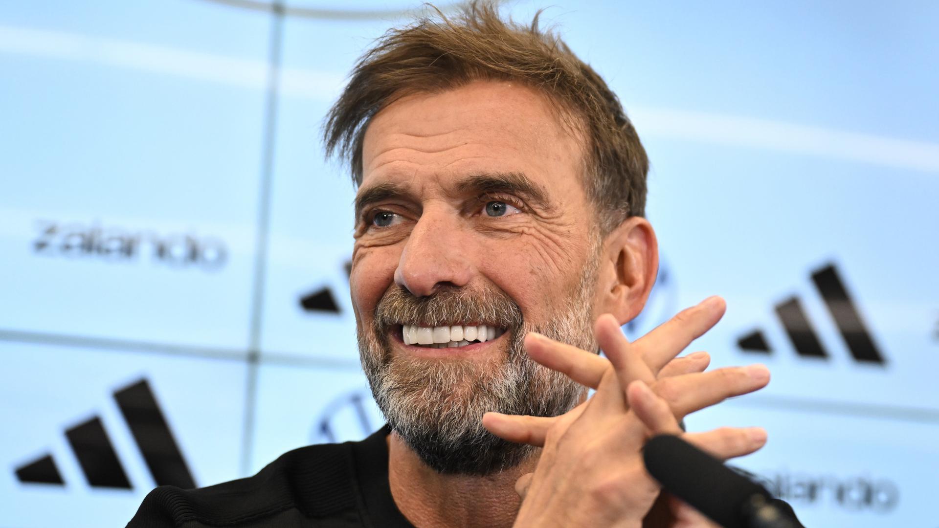 Jürgen Klopp lächelt bei einer Pressekonferenz. Jürgen Klopp lächelt bei einer Pressekonferenz.