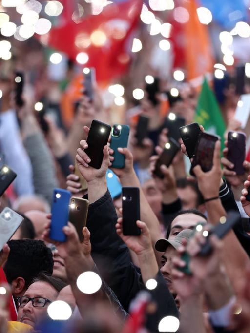 Wahlkampfveranstaltung in Istanbul. Zahlreiche Menschen halten ihr Smartphone nach oben.