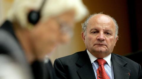 Abgebildet ist ein älterer Herr, der melancholisch nach unten schaut. Es ist Jakob Finci, Vorsitzender der jüdischen Gemeinde in Sarajevo und Präsident des Vereins Bosnien und Herzegowina 2005, und unscharf im Vordergrund Carla del Ponte, Chefanklägerin des Internationalen Strafgerichtshofs für das ehemalige Jugoslawien. 