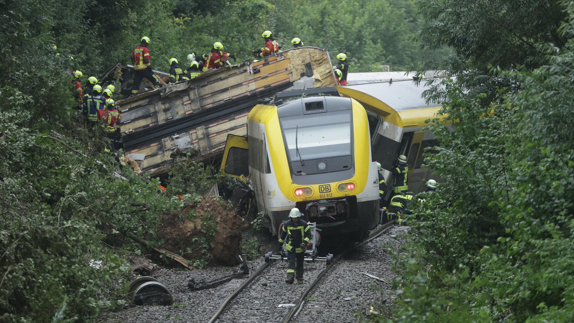 Rettungskräfte suchen in einem entgleisten Zug nach Fahrgästen. Rettungskräfte suchen in einem entgleisten Zug nach Fahrgästen.