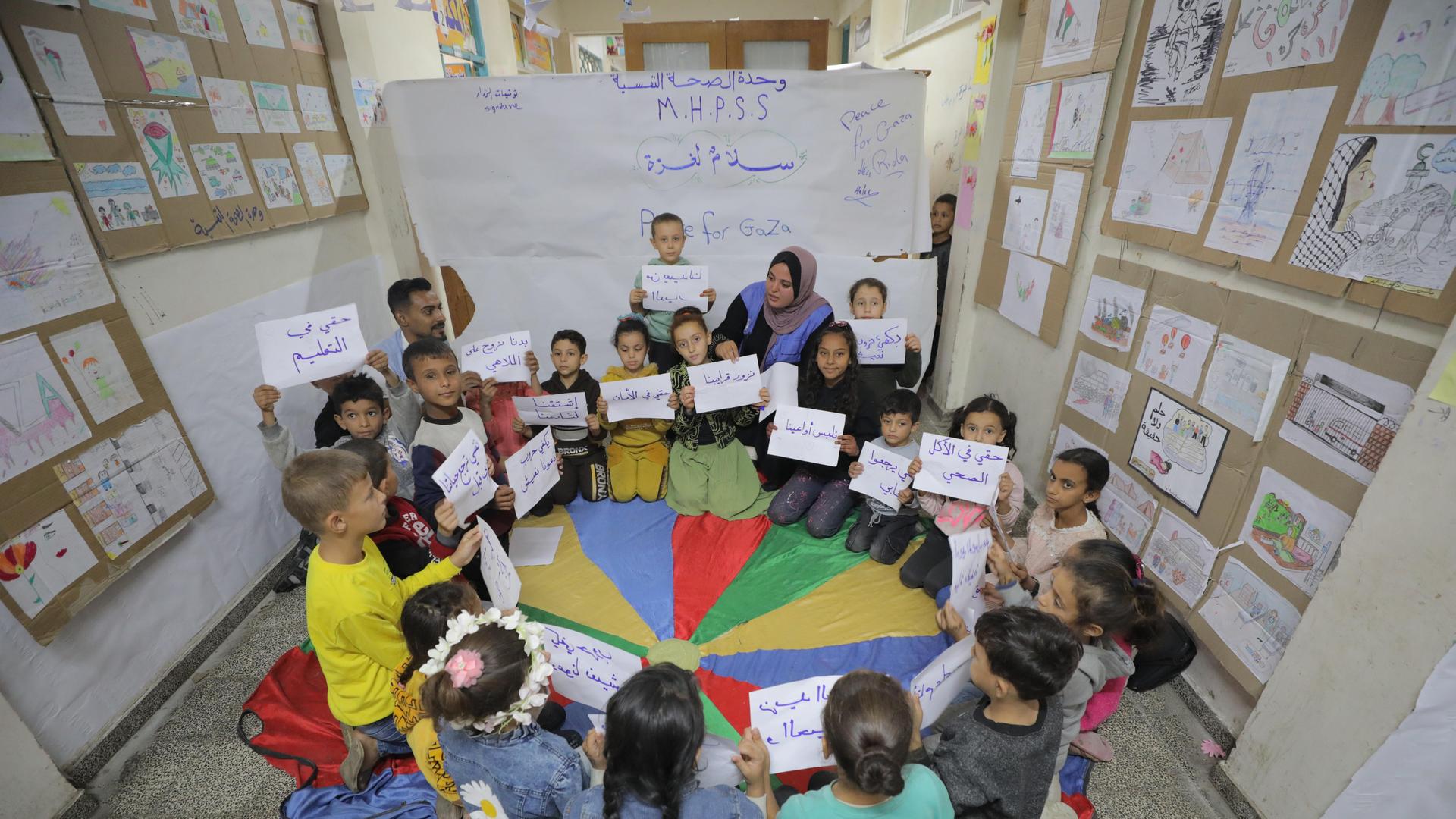 DEIR AL-BALAH, GAZA - 31. OKTOBER: Palästinensische Kinder tragen Anti-Kriegs-Transparente während des Besuchs von Heli Uusikyla.