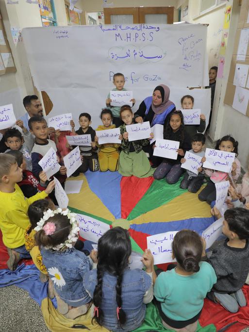 DEIR AL-BALAH, GAZA - 31. OKTOBER: Palästinensische Kinder tragen Anti-Kriegs-Transparente während des Besuchs von Heli Uusikyla.