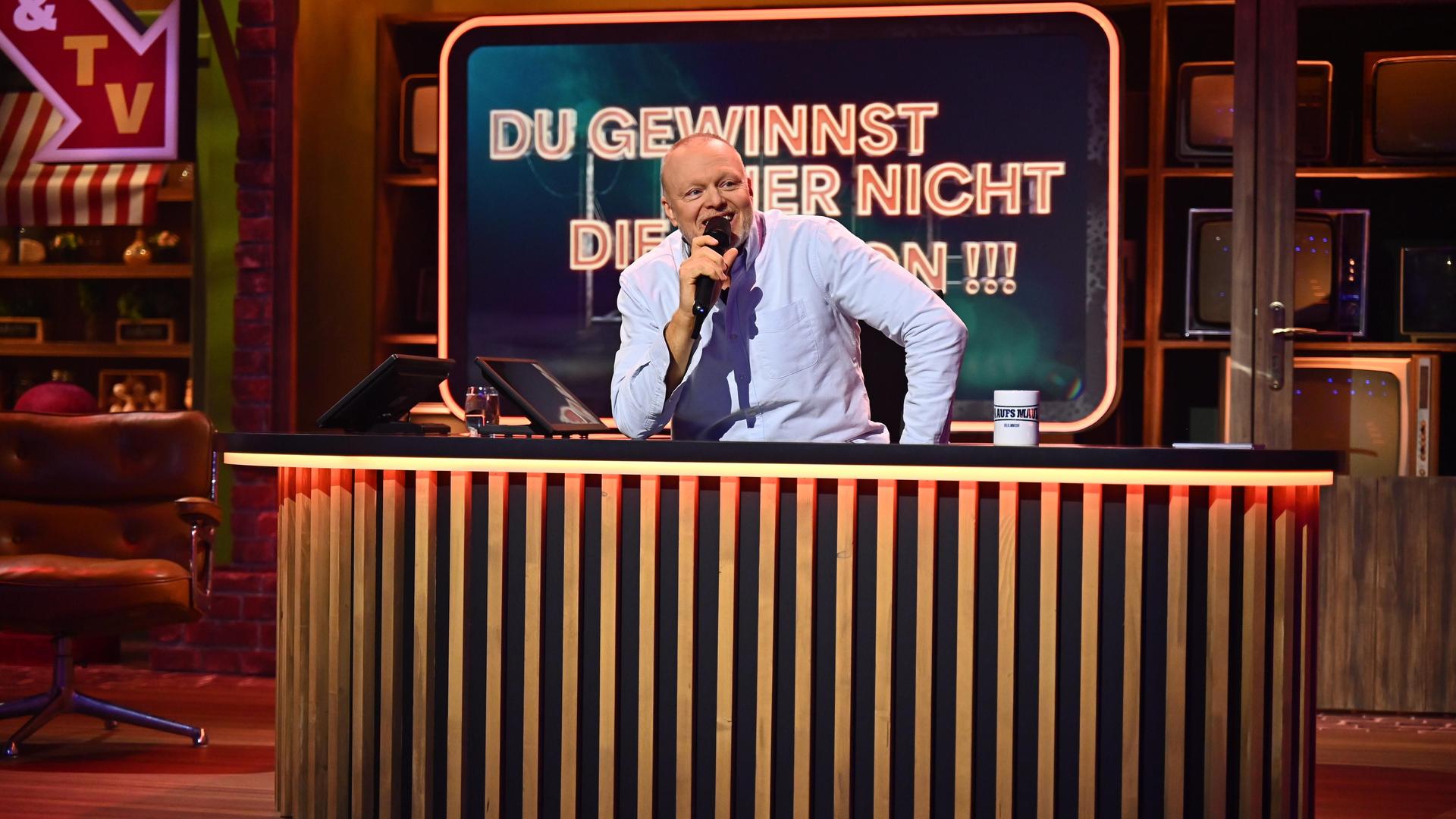 Stefan Raab sitzt bei einer Sendung "Du gewinnst hier nicht die Million" hinter einem Pult und spricht in ein Mikrofon. Stefan Raab sitzt bei einer Sendung "Du gewinnst hier nicht die Million" hinter einem Pult und spricht in ein Mikrofon.