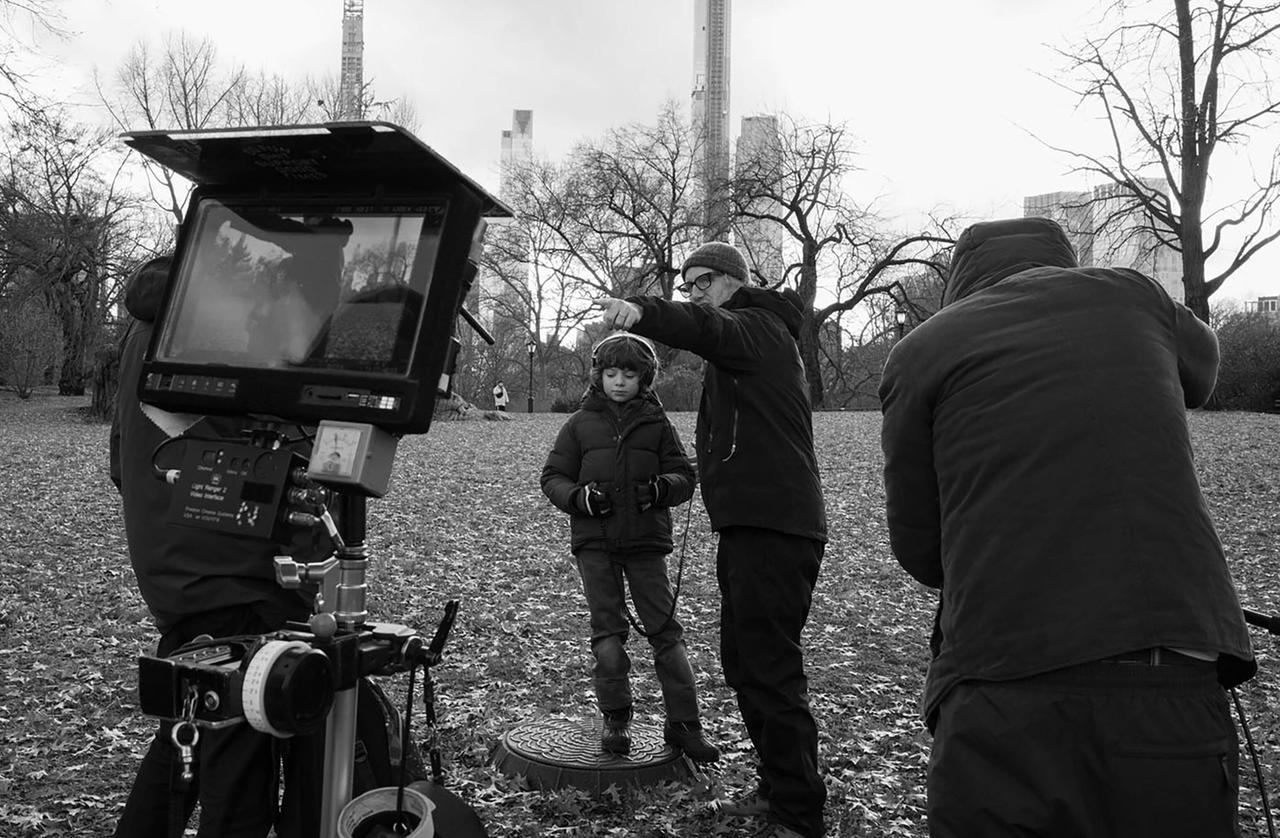Regisseur Mike Mills erläutert Kinderdarsteller Woody Norman die nächste Szene. Sie stehen in einem Park, im Vordergrund ein Monitor und der Kameramann. 