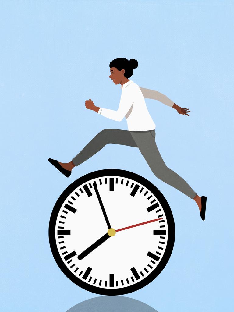 Eine Frau springt vor blauem Hintergrund über eine Uhr.

