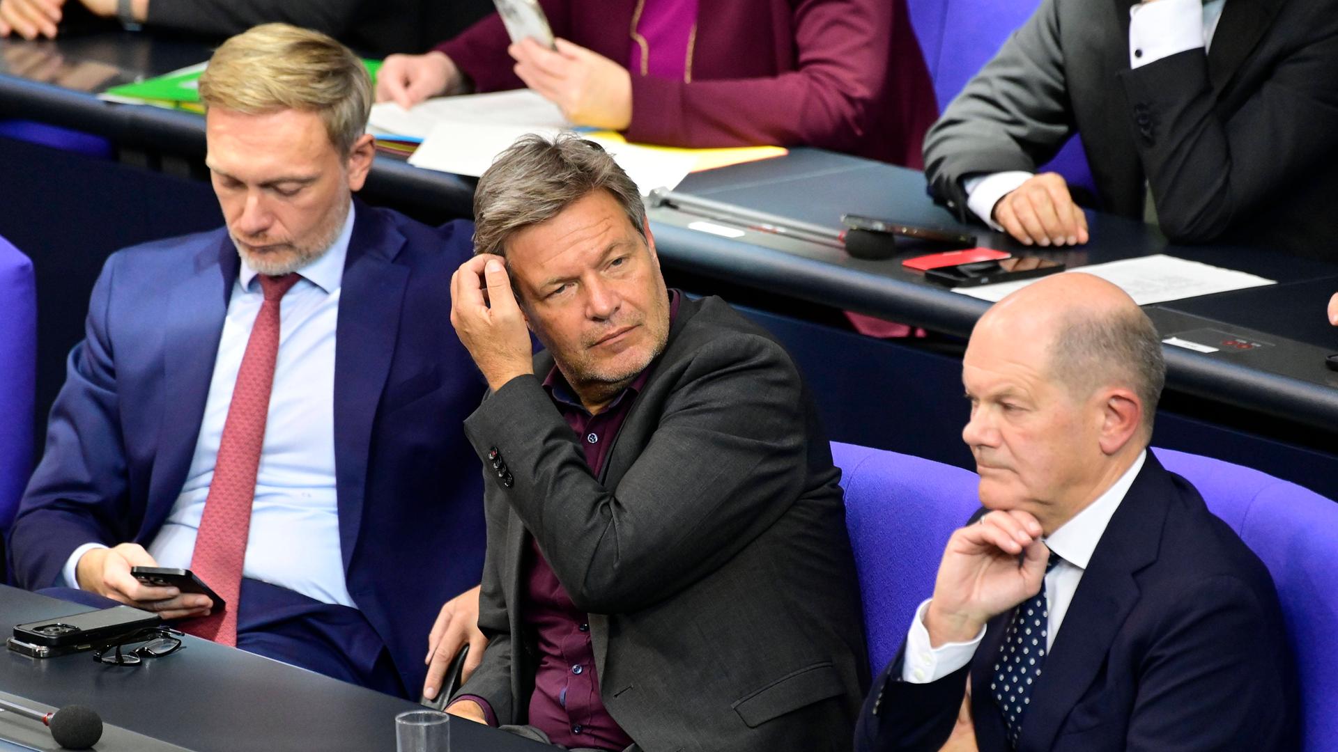 Christian Lindner (li.), Robert Habeck und Olaf Scholz (re.) sitzen auf der Regierungsbank im Deutschen Bundestag. 