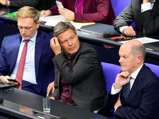 Christian Lindner (li.), Robert Habeck und Olaf Scholz (re.) sitzen auf der Regierungsbank im Deutschen Bundestag. 